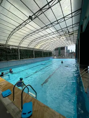 a large swimming pool with people in the water at A Venue Residences 80N in Manila