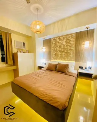 a bedroom with a large bed and a chandelier at Serenity Suite Smart Condo 2 BR Balcony in Manila