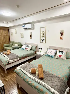 a bedroom with two beds and a couch at Sybay Suites twin double bed beside Okada near T3 MOA NAIA Ayala MSV1517H in Manila