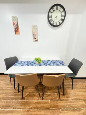 a table with chairs and a clock on the wall at Sybay Suites twin double bed beside Okada near T3 MOA NAIA Ayala MSV1517H in Manila