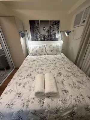 a white bed with two pillows on it at 1BR Luxury Apartment The Camden Place in Manila