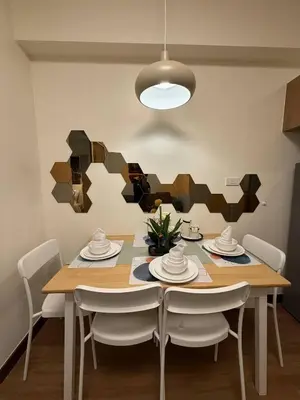 a dining room with a wooden table and chairs at 1BR Luxury Apartment The Camden Place in Manila