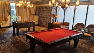 a living room with a pool table and chairs at The Oasis in Knigthsbridge Residence, Makati in Manila