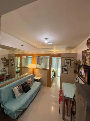 a living room with a couch and a table at Sea Residences Mall of Asia in Manila