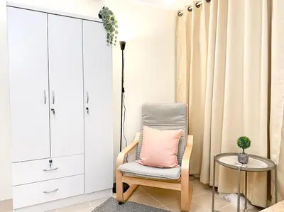 a chair with a pink pillow in a room at Kasara Urban Resort Residences by Amari Staycations in Manila