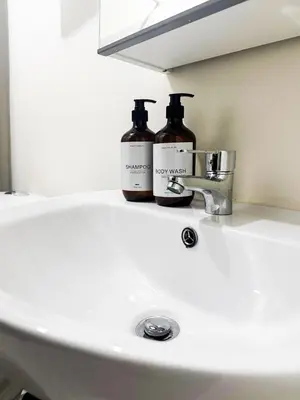 two bottles of soap sitting on a bathroom sink at Kasara Urban Resort Residences by Amari Staycations in Manila