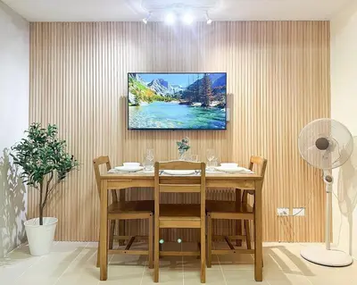 a dining room with a table and a painting on the wall at Kasara Urban Resort Residences by Amari Staycations in Manila