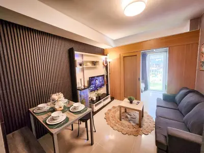 a living room with a couch and a table at Amazing Poolside 1br MOA Netflix 100mbps fiber in Manila