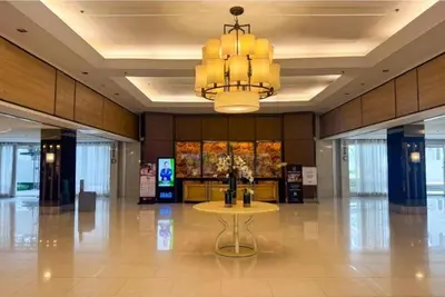 a large lobby with a table and a chandelier at Amazing Poolside 1br MOA Netflix 100mbps fiber in Manila