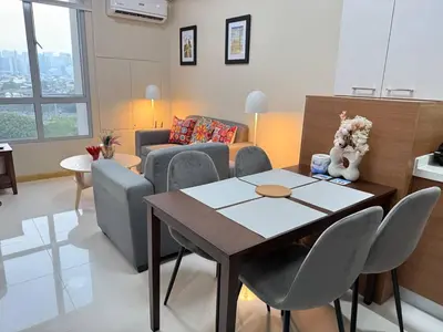 a living room with a table and a couch at European Vibe 1BR Great River City View Free Pool Gym Internet Netflix in Manila
