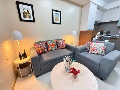 a living room with a couch and a table at European Vibe 1BR Great River City View Free Pool Gym Internet Netflix in Manila