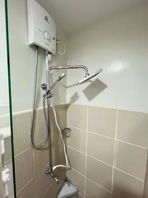 a shower in a bathroom with a shower head at Paris Theme Near Ayala Feliz Mall 2BR Netflix Internet with Pool Parking Fee in Manila