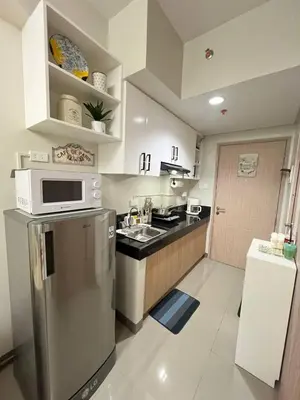 a kitchen with a stainless steel refrigerator and a microwave at Paris Theme Near Ayala Feliz Mall 2BR Netflix Internet with Pool Parking Fee in Manila