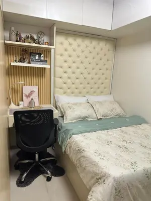 a bedroom with a bed and a desk and a chair at AMD Staycation in Manila