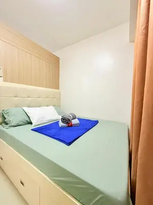 a bedroom with a large bed with a blue blanket at Dreamstaycation shore residences in Manila