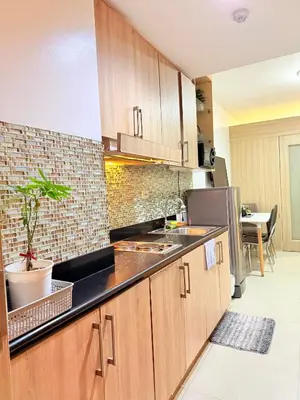a kitchen with wooden cabinets and a counter top at Dreamstaycation shore residences in Manila