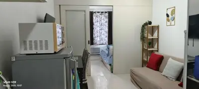 a living room with a couch and a tv on a counter at Sea Residences in Manila