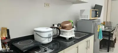 a kitchen counter with a coffee maker and a microwave at Sea Residences in Manila