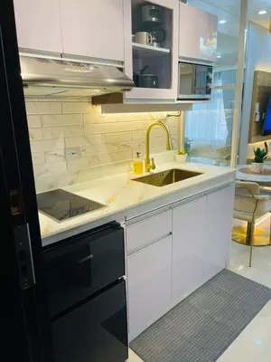 a kitchen with white cabinets and a sink at 19s CAI in Manila