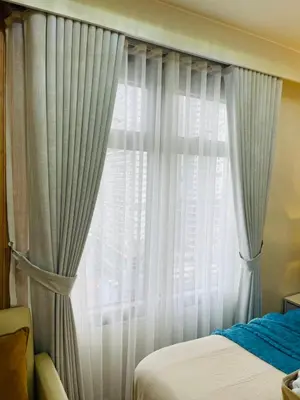 a bedroom with a bed and a window with curtains at 19s CAI in Manila