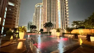 a large fountain in a city with tall buildings at AdahkuMaya Luxury Suites in Manila