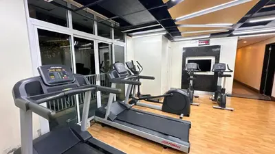 a gym with two tread machines and a treadmill at AdahkuMaya Luxury Suites in Manila