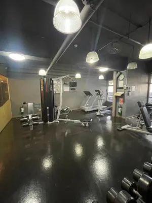a gym with dumbbells and machines in a room at A Venue Residences 80G in Manila