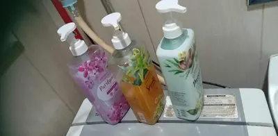 three bottles of cleaning products sitting on top of a toilet at Family Suites 4 Shell Condo MOA 653B in Manila