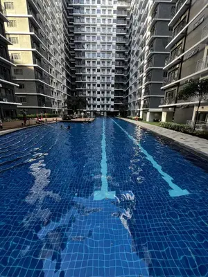 a large blue swimming pool with tall buildings at Suite 07 MOA GRAND STAY Newly Turn over Only in Manila