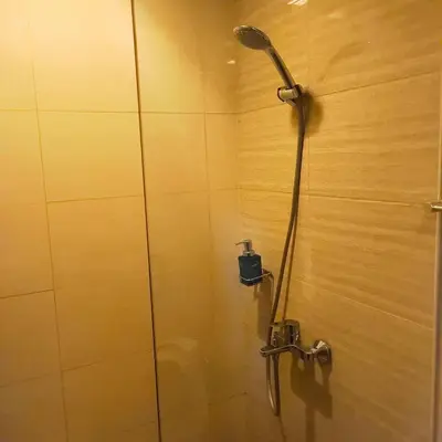 a shower with a shower head in a bathroom at Cozy Modernistic 1 BR with Veranda! in Manila