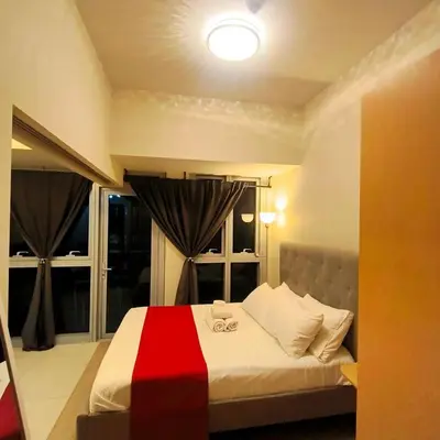 a bedroom with a red and white bed with windows at Cozy Modernistic 1 BR with Veranda! in Manila