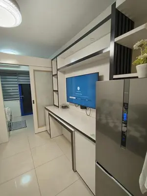 a living room with a tv and a counter at Sea residences MOA-MR in Manila
