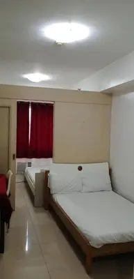 a bedroom with two beds and a red window at Sea residences MOA-MR in Manila