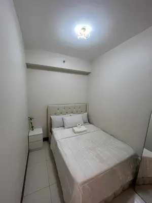a small bedroom with a bed in a room at 2 bedroom modern unit in Manila