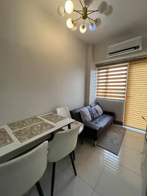 a living room with a table and a couch at 2 bedroom modern unit in Manila