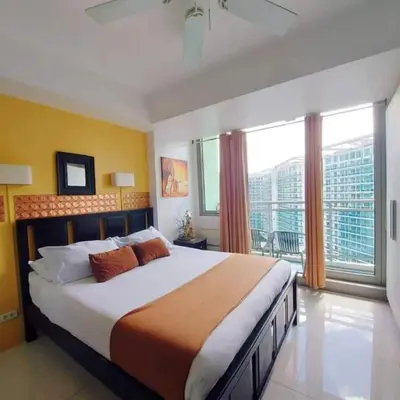 a bedroom with a large bed and a large window at 320 Santorini Staycation in Manila