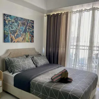 a bedroom with a bed and a large window at 320 Santorini Staycation in Manila