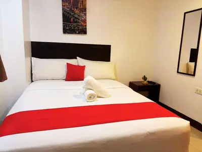 a bedroom with a large bed with a red and white blanket at City Stay Inns Slex Makati in Manila