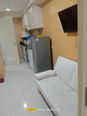 a kitchen with white tile floors and a refrigerator at Kaoru Properties in Manila
