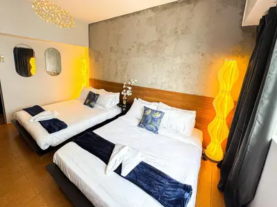 two beds in a room with yellow walls at Destiny Hotel - 1601 in Manila