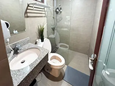a bathroom with a toilet and a sink and a shower at Destiny Hotel - 1601 in Manila