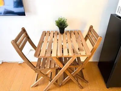 a wooden table with two chairs and a potted plant at Destiny Hotel - 1601 in Manila