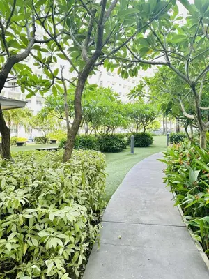 a sidewalk in a park with trees and bushes at Cg's Staycations in Manila