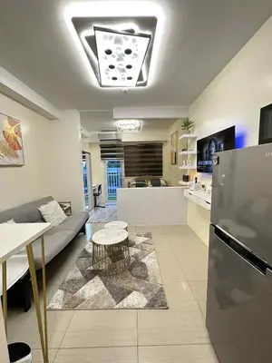 a living room with a couch and a kitchen at Cg's Staycations in Manila