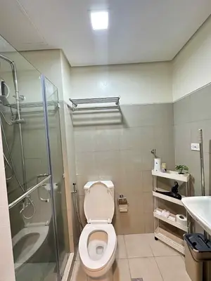 a bathroom with a shower and a toilet and a sink at Cg's Staycations in Manila