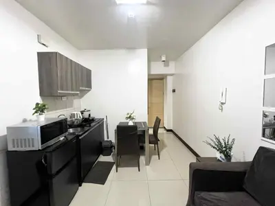 a kitchen and living room with a microwave and a table at Solemare parksuites with balcony tower C in Manila