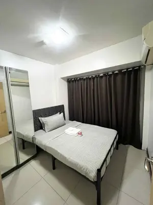 a bed in a room with a black curtain at Solemare parksuites with balcony tower C in Manila