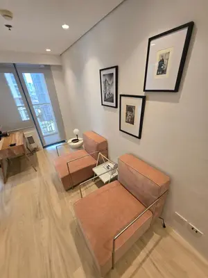 a living room with two chairs and a table at Hygge-ParkWest BGC near Grand Hyatt & Mitsukoshi in Manila