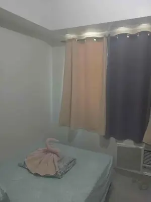 a room with a bed and a window and a room with at Pasay Staycation across MOA in Manila