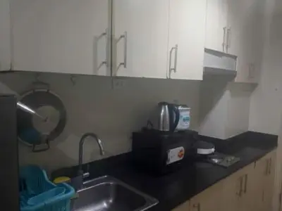 a kitchen counter with a sink and a microwave at Pasay Staycation across MOA in Manila